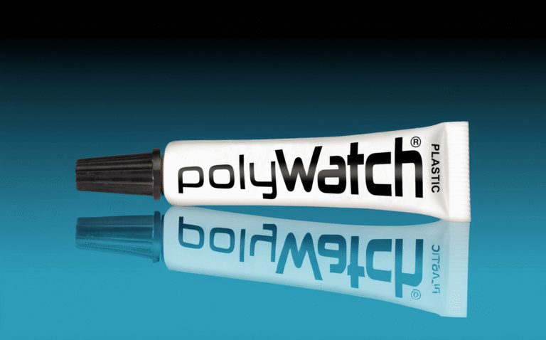 A tube of Polywatch Plastic polish on a reflective blue surface, used for removing scratches from acrylic watch crystals.
